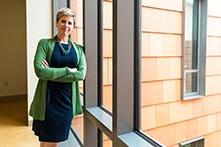 image of Kirstin Landis-Piwowar leaning against a window in the Human Health Building