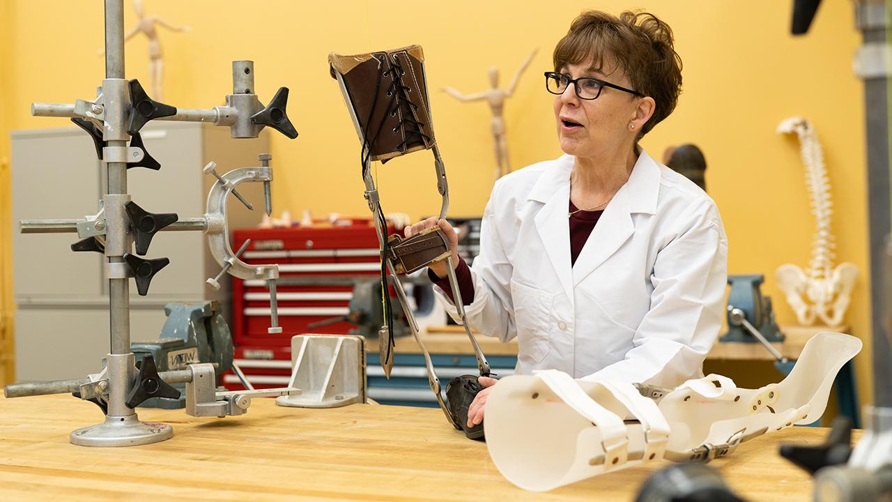 Woman standing next to a table with prosthetic devices