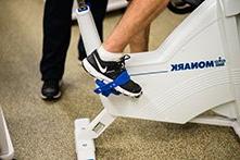 A person's foot pedaling an exercise bike.